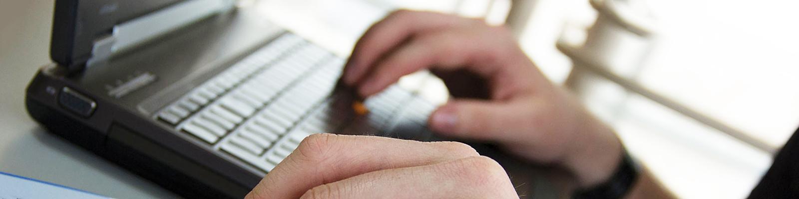 Hands on a laptop keyboard